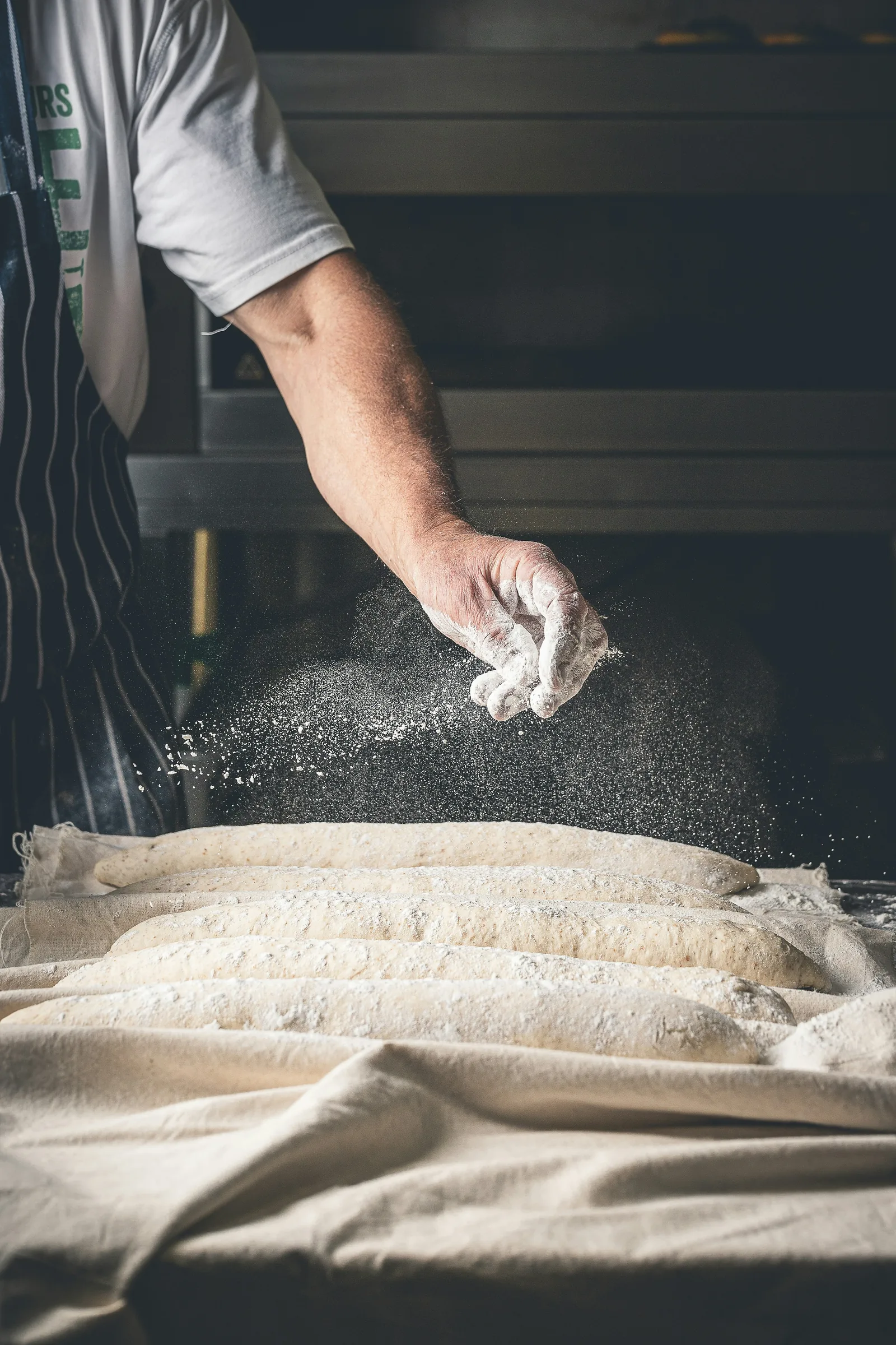 Main de boulanger farinant les pâtes